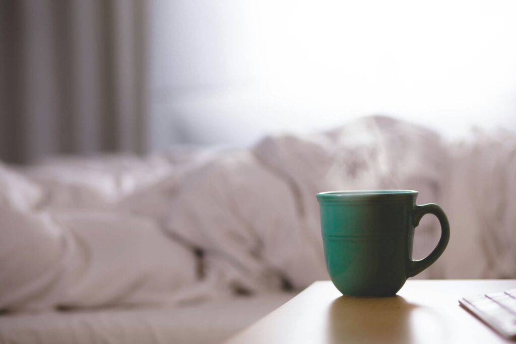 Uma mesa com uma xícara com uma bebida quente, normalmente encontrado com pessoas sob tratamento de resfriado.