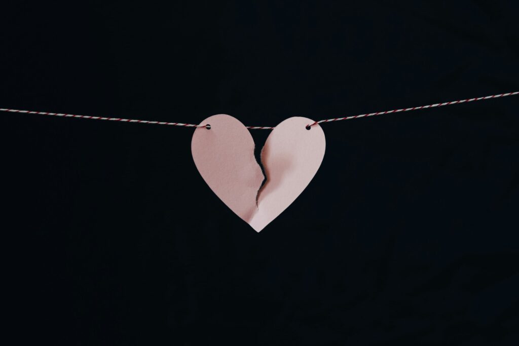 Um coração de papel rasgado no meio representando a síndrome do coração partido. Foto de Kelly Sikkema na Unsplash