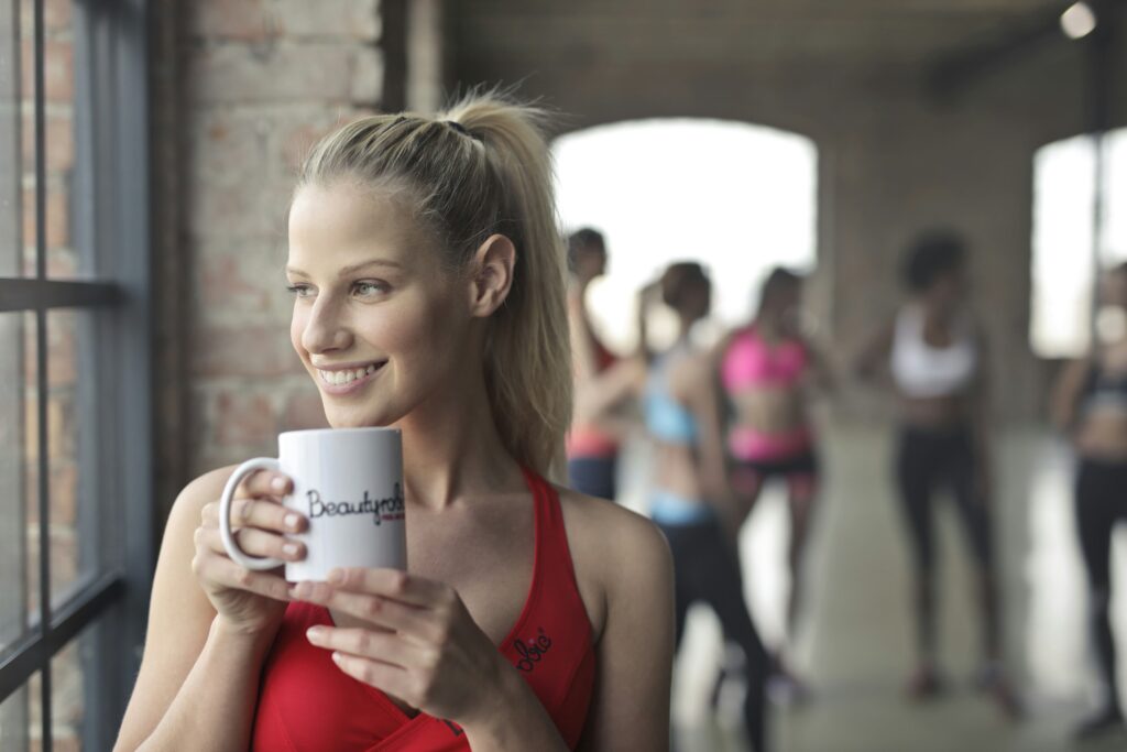 Imagem de uma mulher jovem segurando uma xícara de café representando a cafeína e fertilidade.