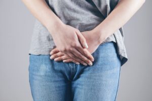 Imagem de uma mulher vestida com calça jeans e camiseta, com as mãos sobrepostas sobre suas partes íntimas, representando a suspeita de vaginose bacteriana. Foto de Sasun Bughdaryan na Unsplash
