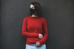 Imagem de uma mulher com o braço sobre o corpo e com olhar distante, simbolizando a preocupação de uma candidíase ser crônica. Foto de engin akyurt na Unsplash
